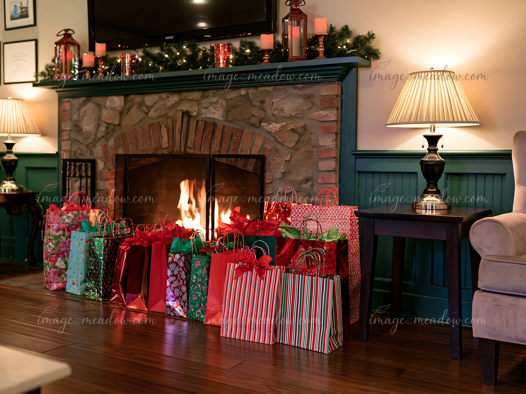 Colorful holiday shopping bags sit on the floor beside a lit stone fireplace in a warmly decorated room.