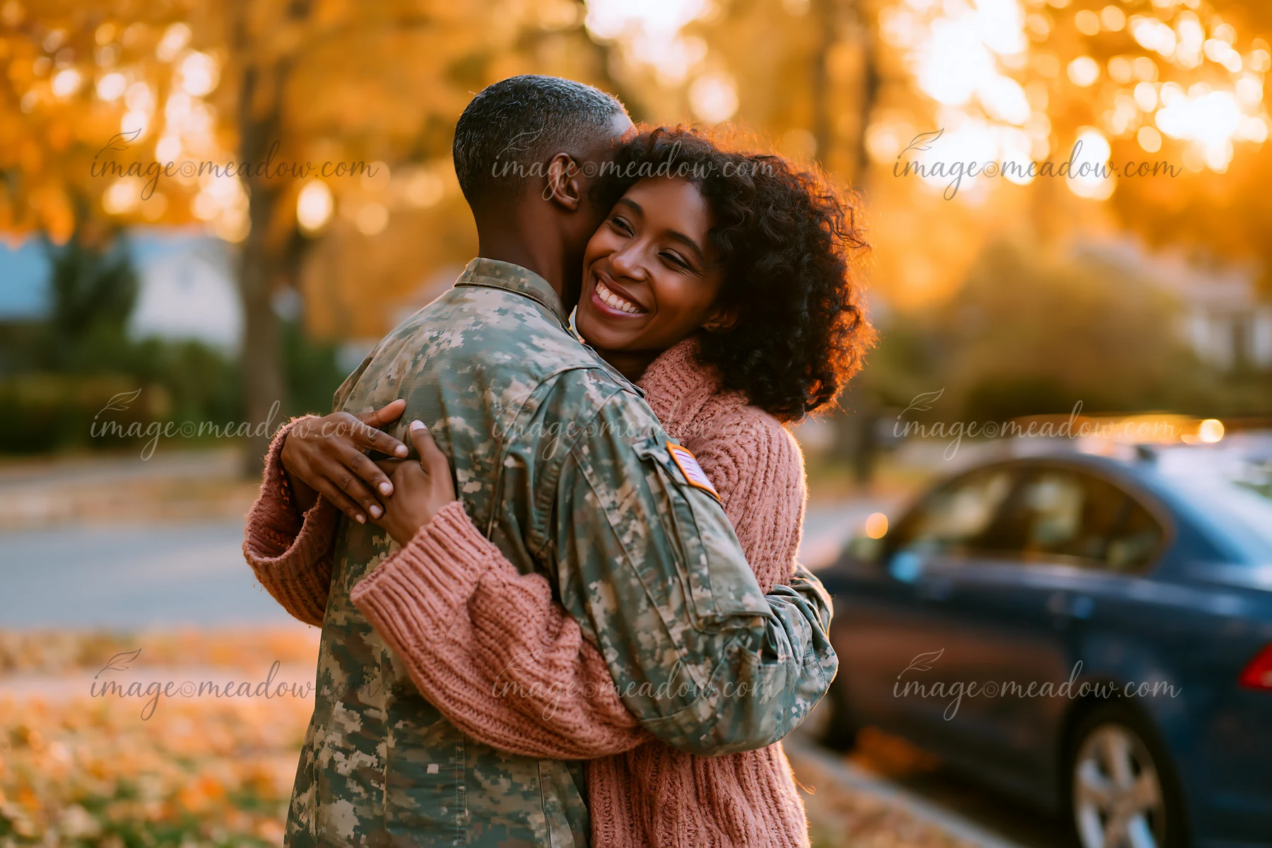 Couple embracing on a tree-lined street in warm golden autumn light