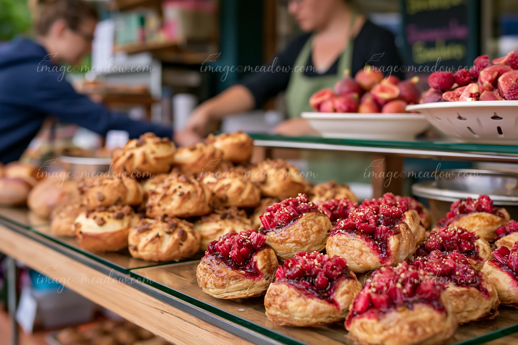 Fresh pastries are arranged on display at a bakery, showing various sweet treats.
