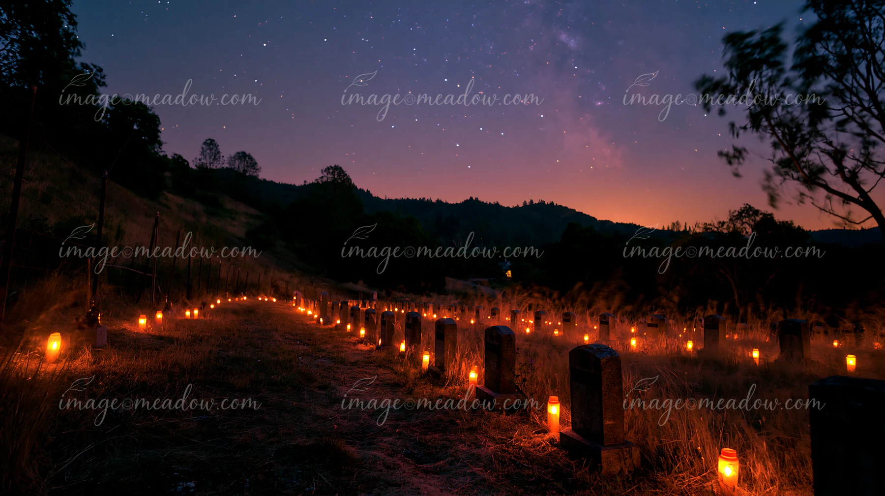 Memorial candles lining military graves under stars illuminate the night.