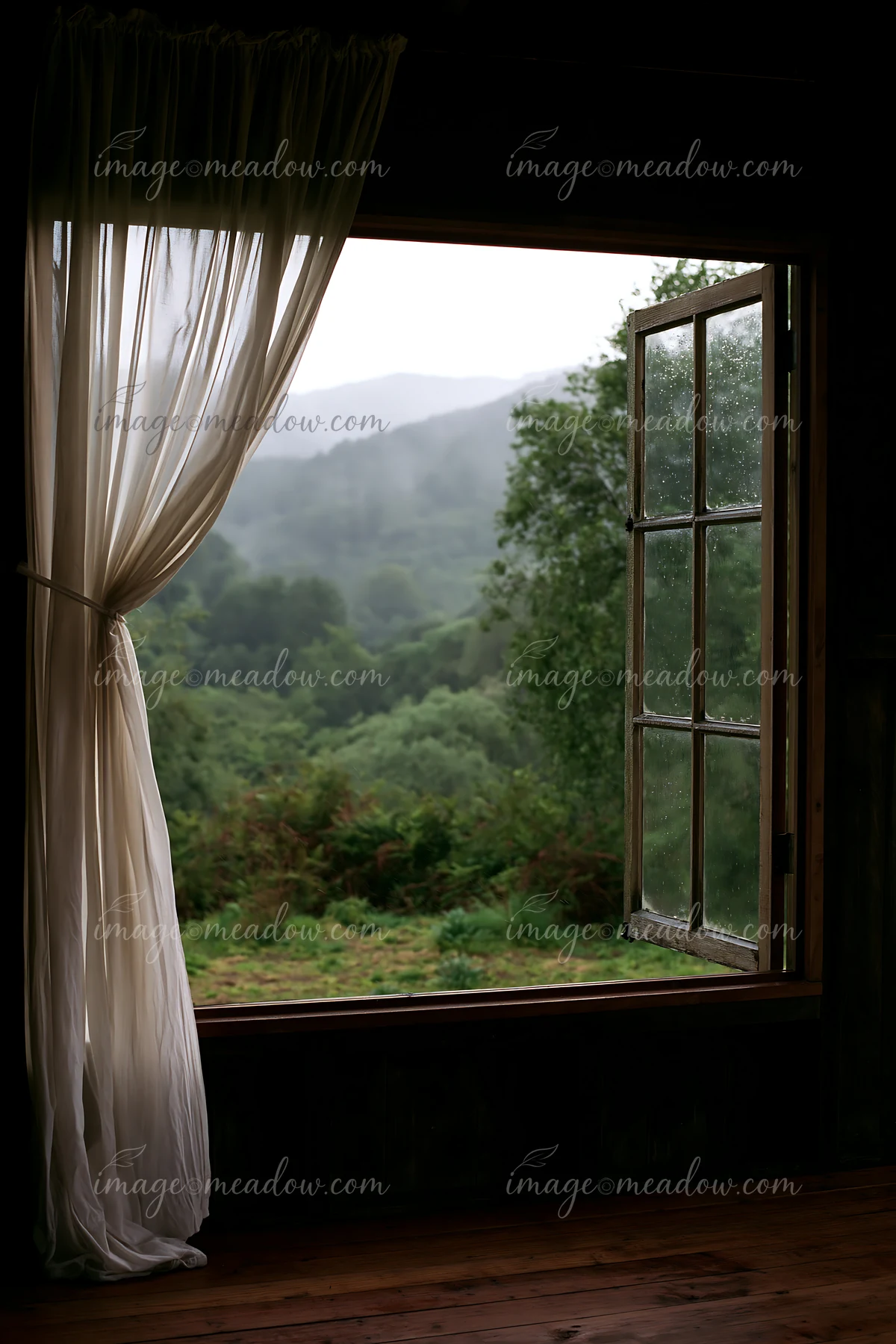 Rain drips on a cabin window while the view shows a green mountain landscape under a gray sky.
