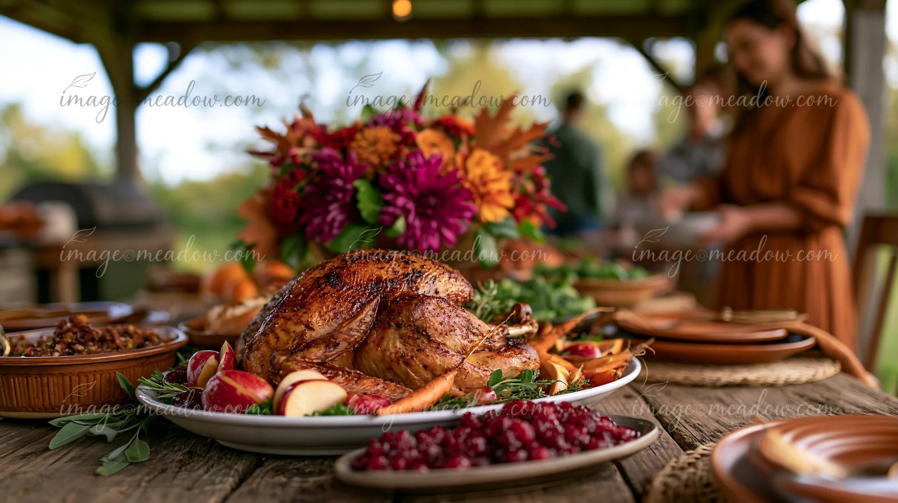Roasted turkey surrounded by autumn produce and side dishes on a festive outdoor dining table.