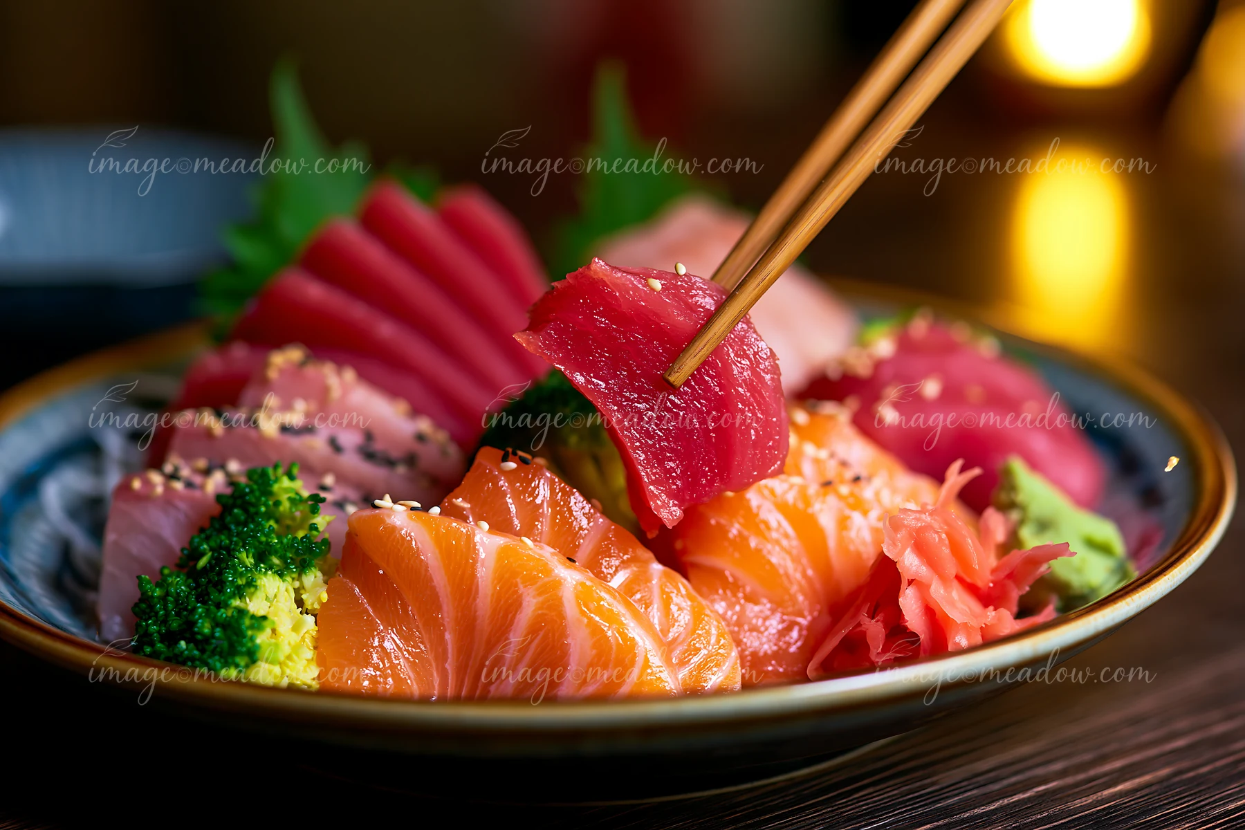 Sashimi platter with pickled ginger features various types of raw fish including salmon and tuna, served with vegetables.
