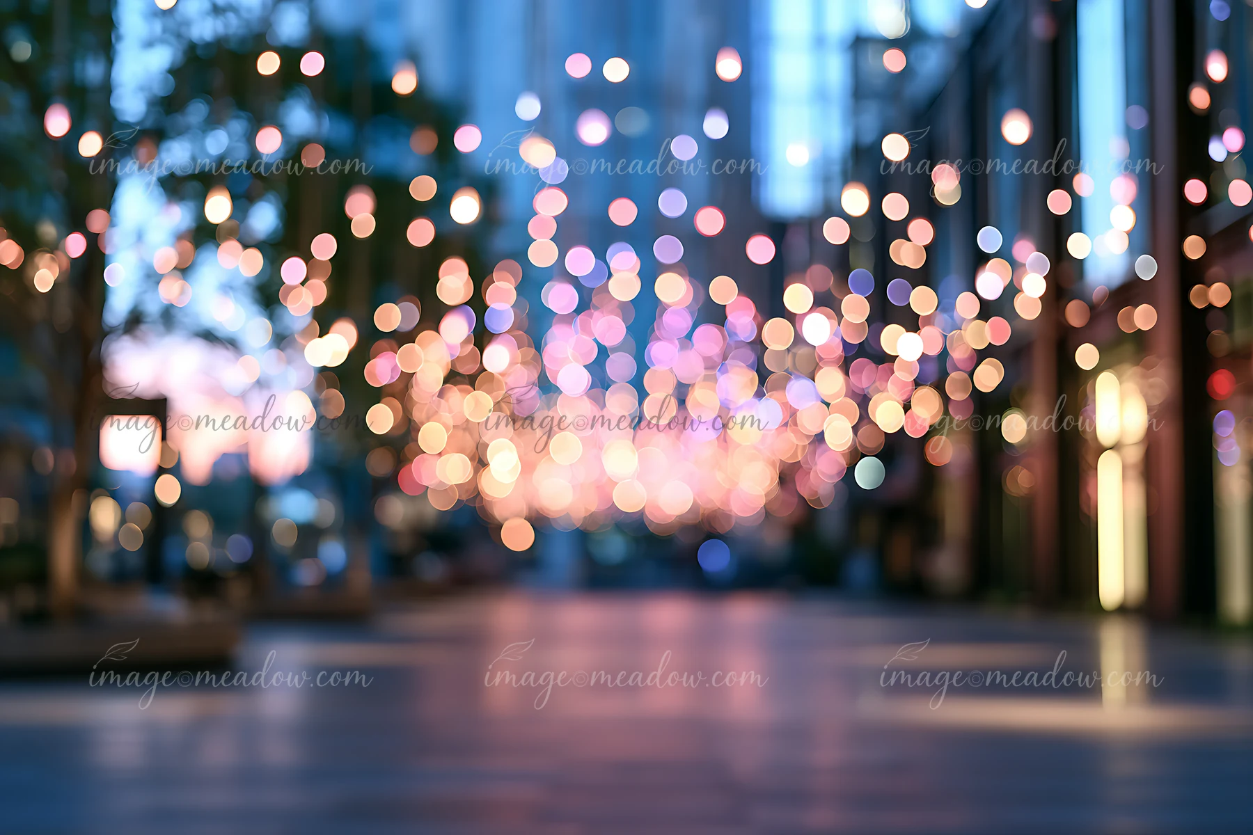 Strings of lights create a vibrant atmosphere in a city street at twilight.