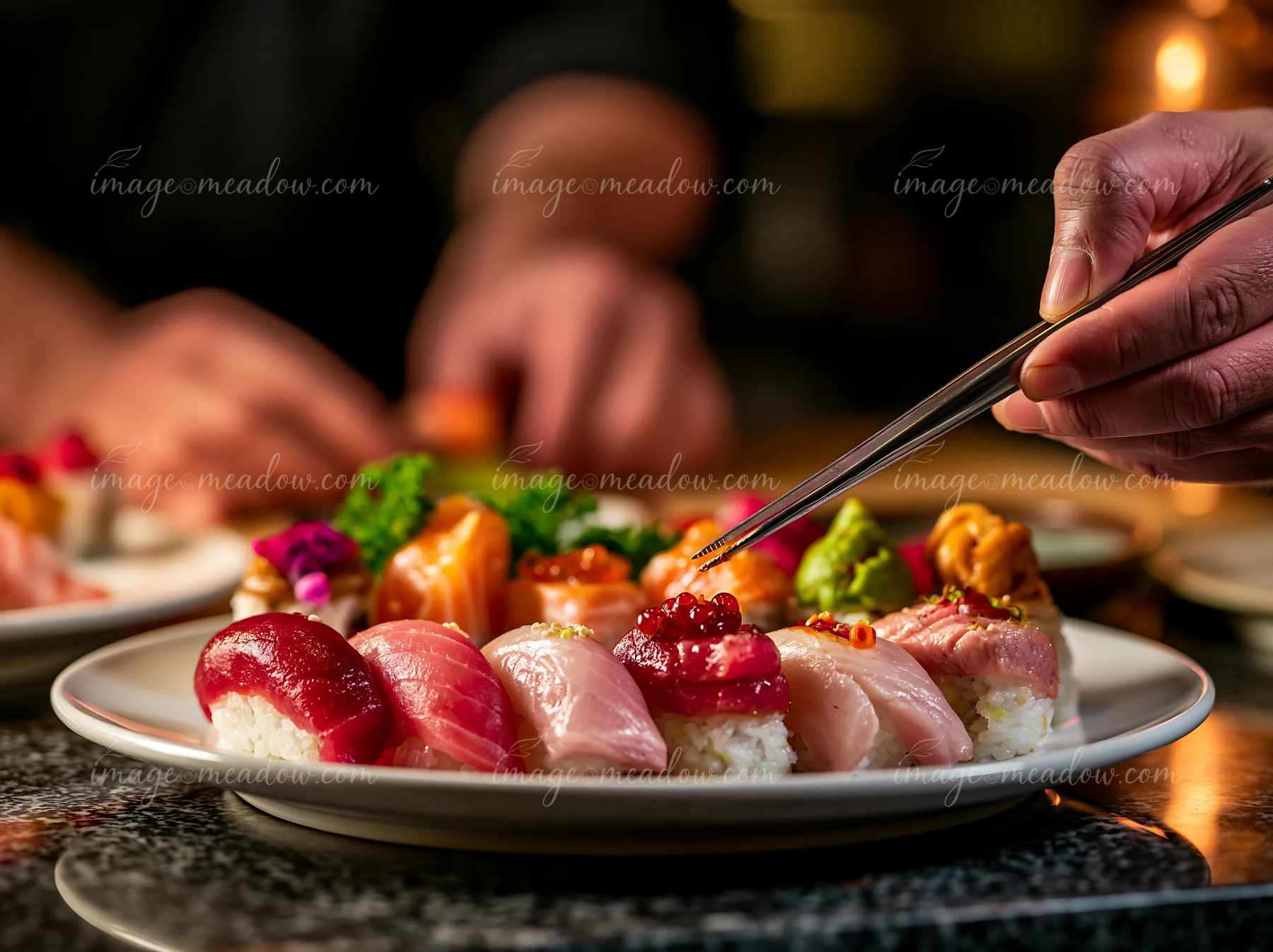 Sushi is arranged on a plate with various toppings as a person uses chopsticks to pick a piece.