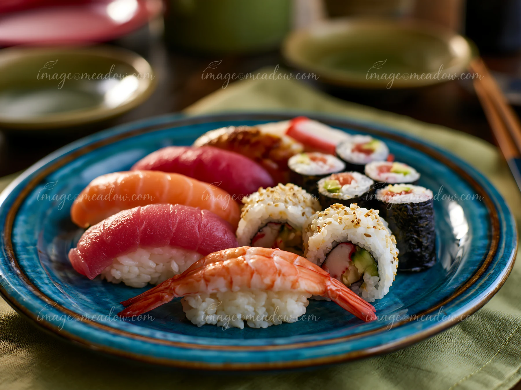 Sushi items arranged on a blue plate feature various types of fish and rolls, with a wooden table in the background.