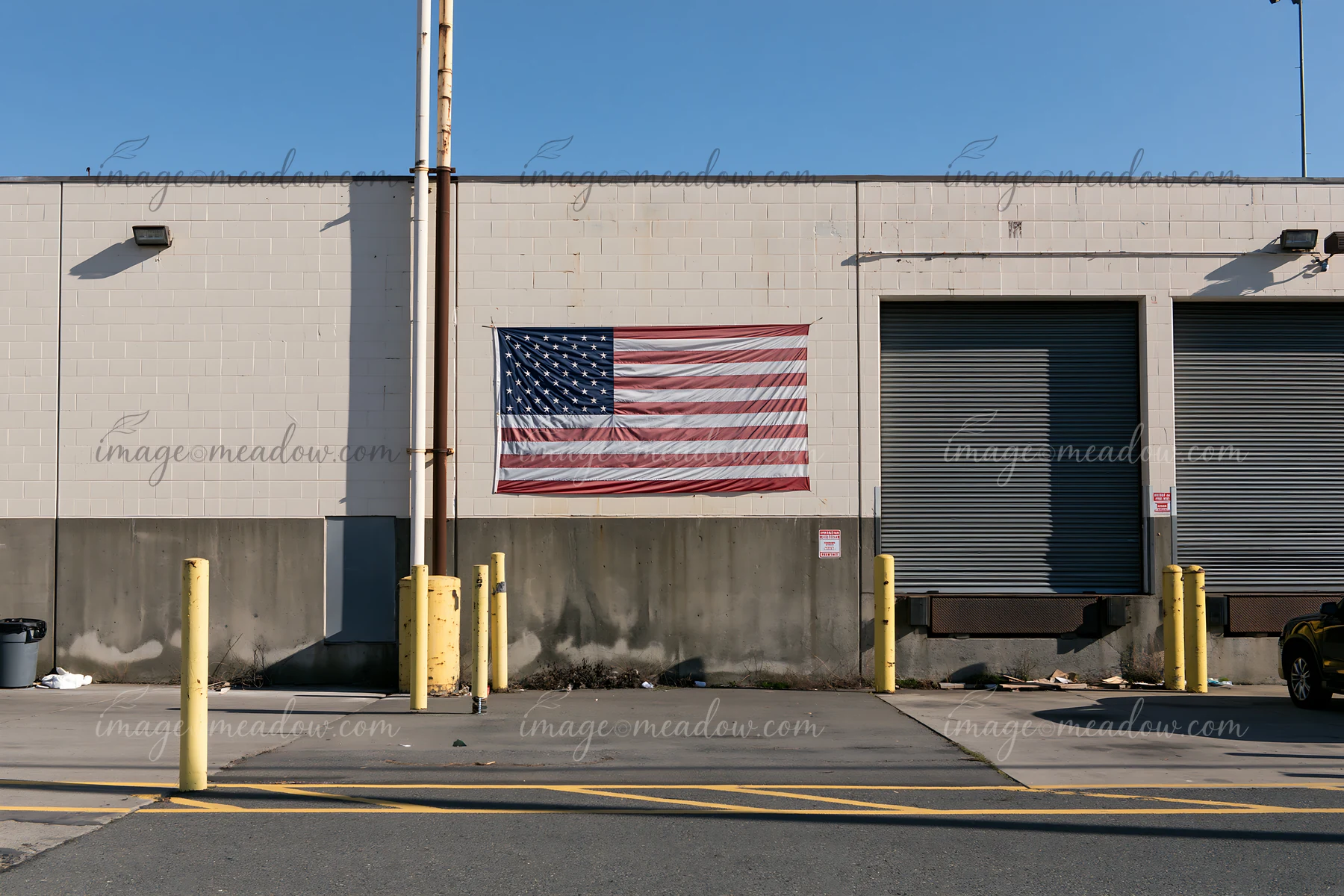 The American flag is displayed on the exterior wall of a factory.