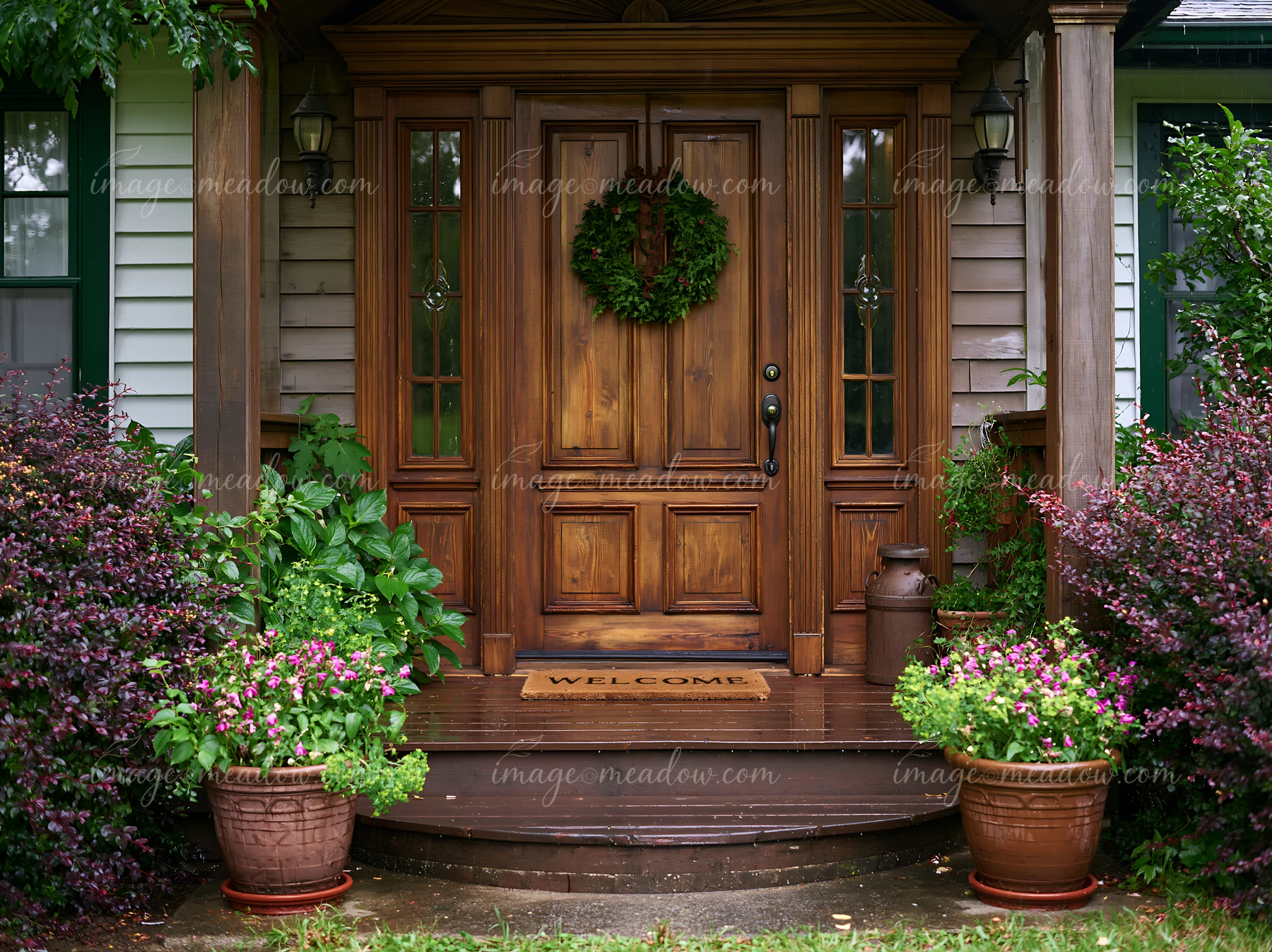 The rustic wooden front door features a green wreath and a welcome mat.