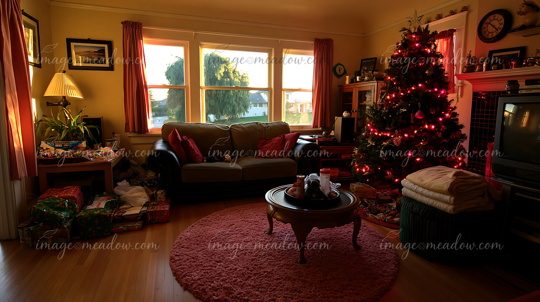 This living room features a Christmas tree with lights and presents scattered around.