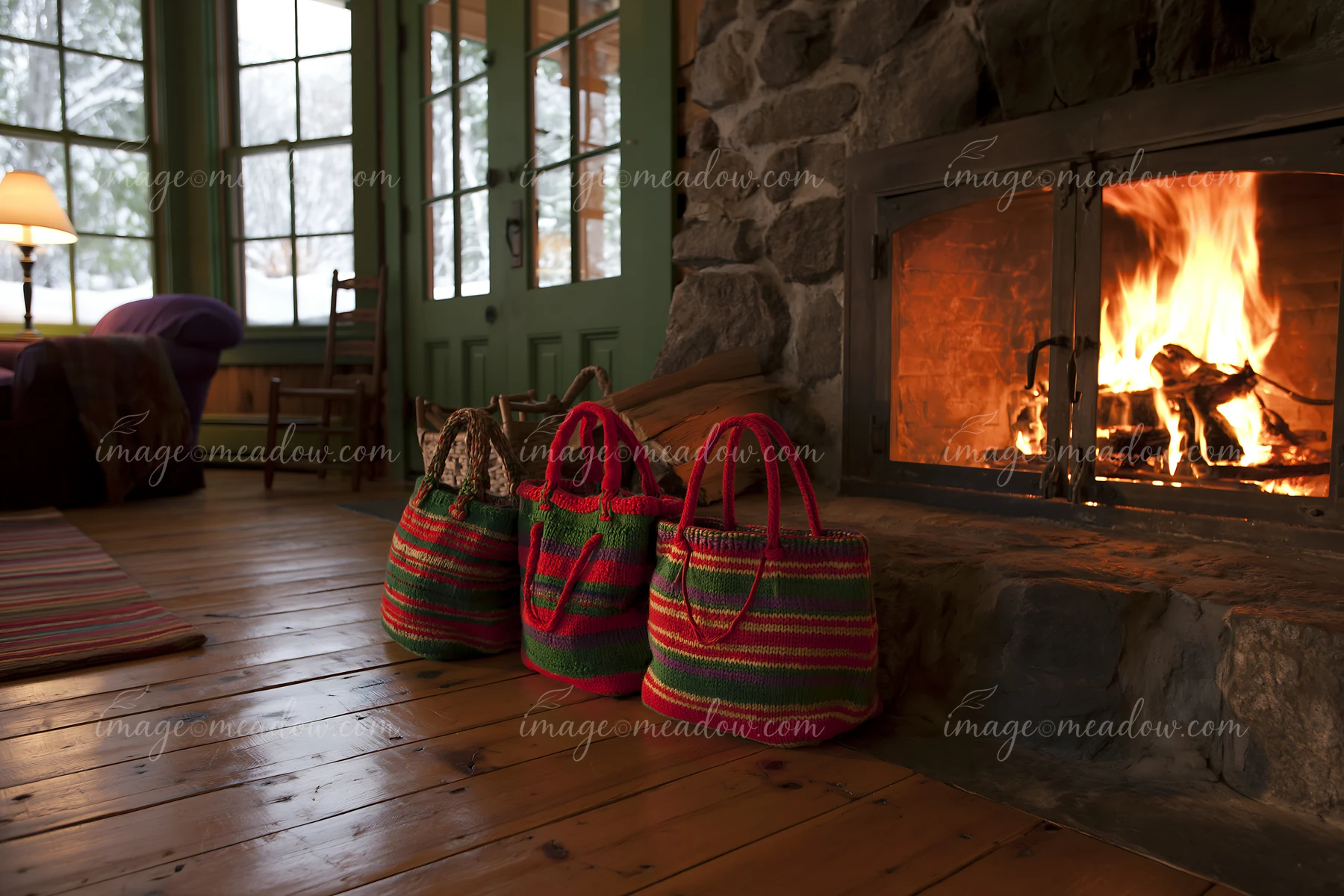 Three colorful shopping bags sit beside a stone fireplace in a cabin.