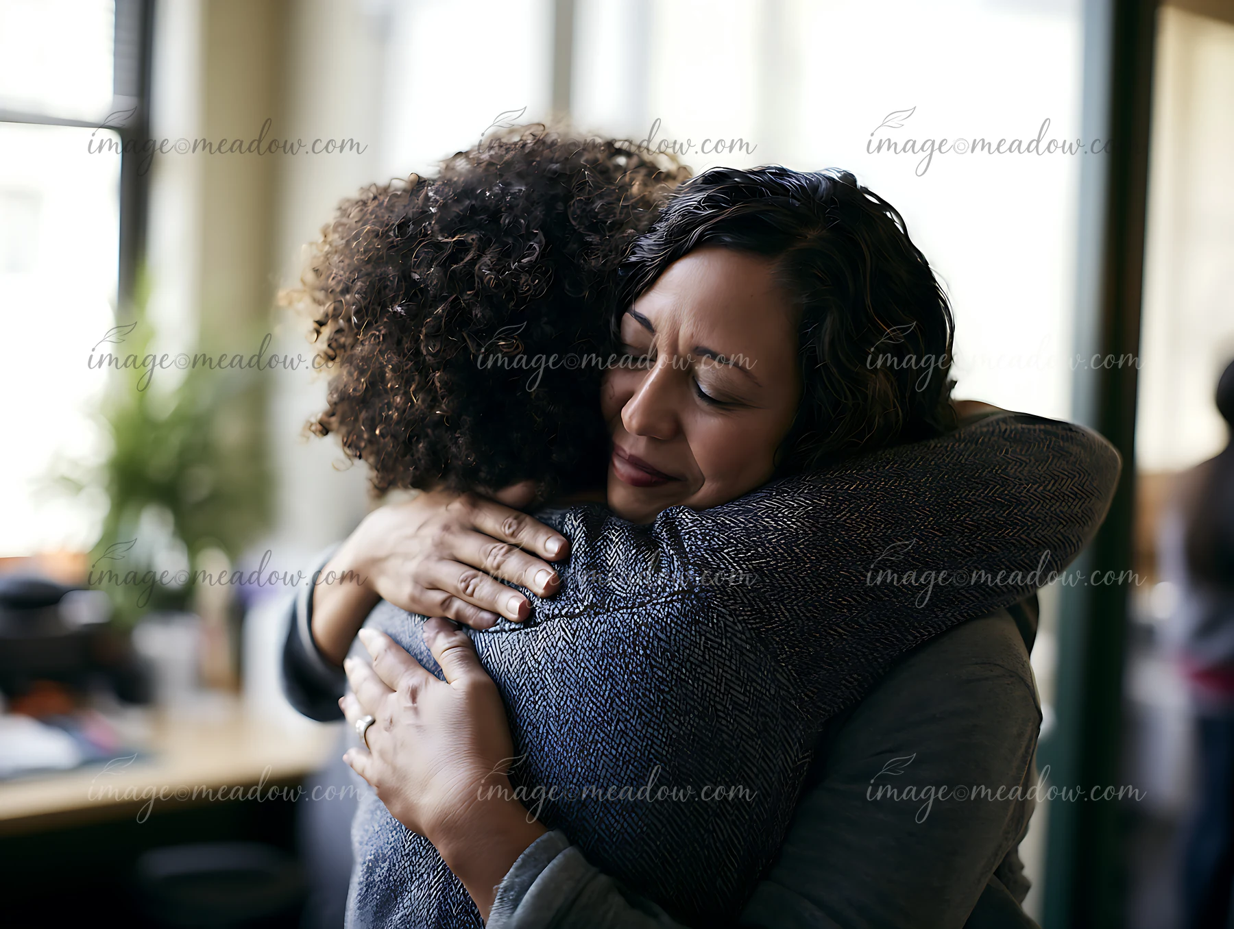 Two adults are embracing in a cozy indoor space.