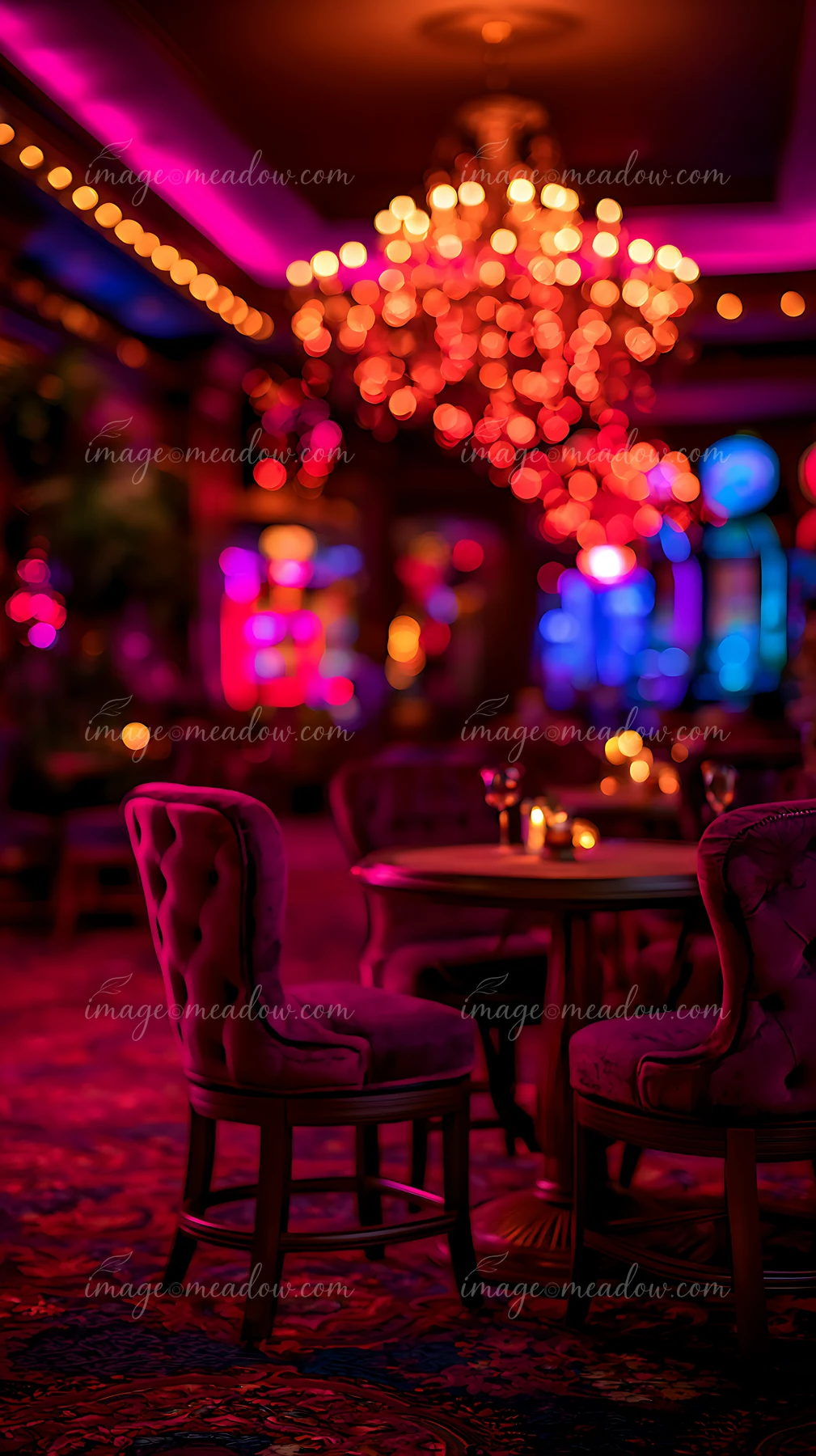 Two elegant chairs are placed beside a table in a vibrant lounge filled with colorful lights.