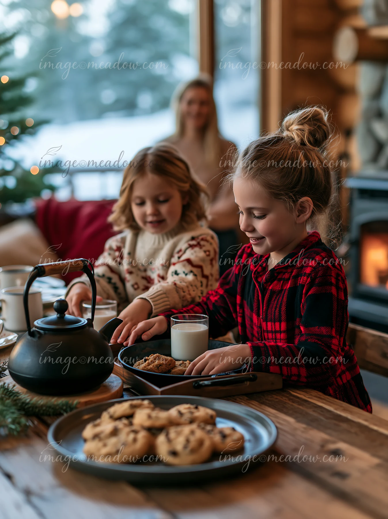 Two young sisters set out milk and cookies on a wooden table in a cabin.