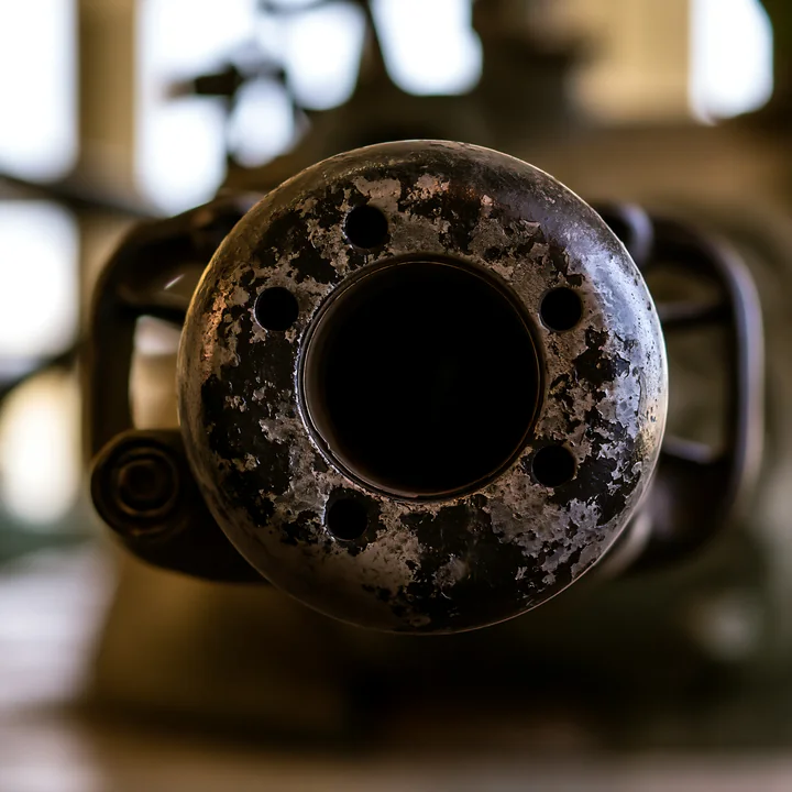 The close-up view displays a panzer tank gun barrel detail showcasing rust and wear patterns.