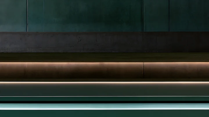 The scene depicts a minimal interior with smooth surfaces, featuring lines of discreet lighting along the wall and floor.