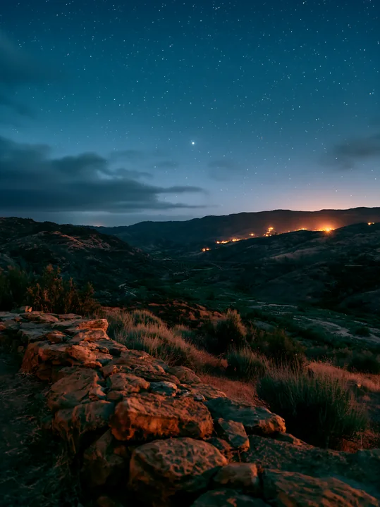 A clear night sky filled with stars shows a mountain valley.