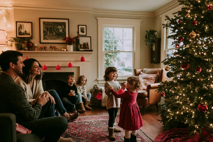 A group of family members enjoys a holiday celebration in a cozy living room.