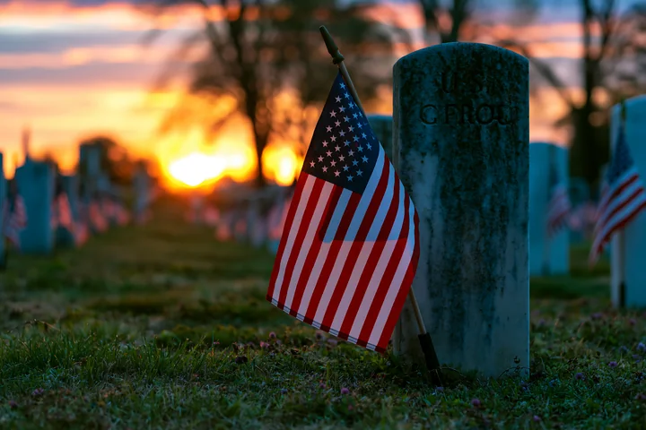 A military cemetery is bathed in soft light from the sunrise after a starry night.