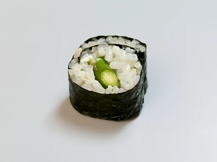 A single sushi piece rests on a plain table.