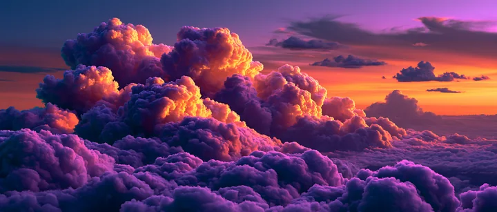 A view of vibrant, colorful clouds filling the sky at sunset, showing a mix of purple, orange, and pink hues.