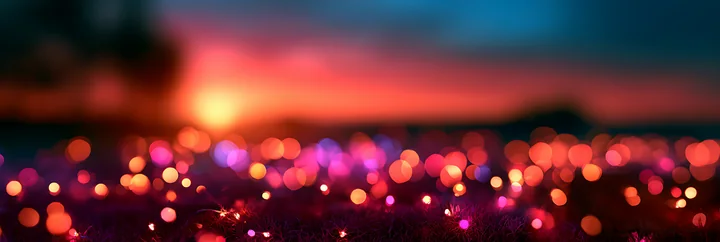 Bright bokeh lights create a vibrant scene as the sun sets, casting warm colors in the sky.