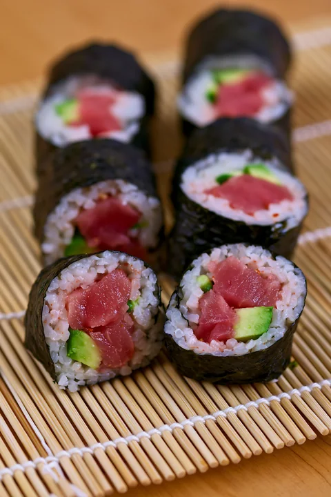 Sliced spicy tuna rolls show a filling of tuna and cucumber.