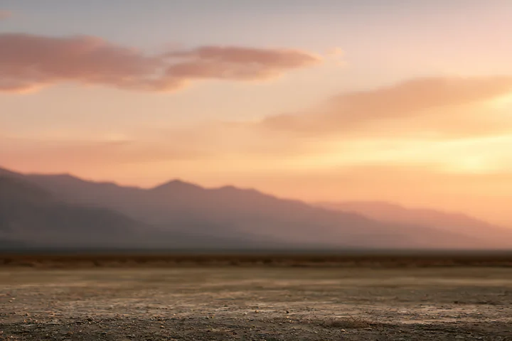 The scene shows a dry desert landscape with a flat terrain under a colorful sunset.