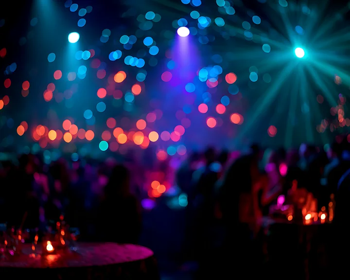 The scene shows a lively party with a crowd gathered, colorful lights shining, and small tables with candles.